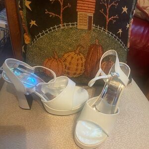 White faux patent leather platform sandals.